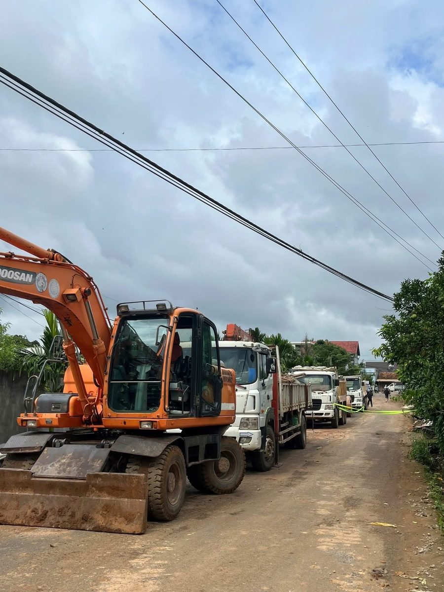 Xe cuốc Doosan và xe tải xếp hàng trên đường gần cầu Tổng Đội, sẵn sàng thi công