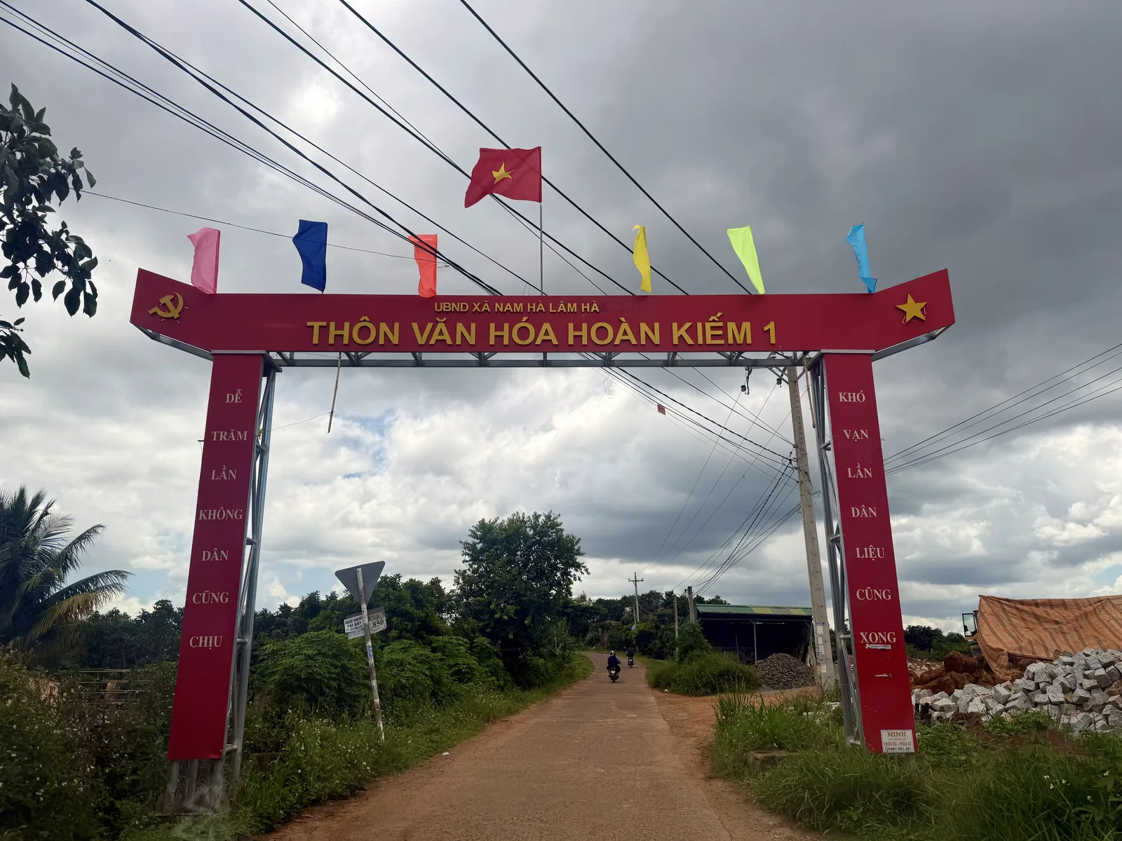 Cổng chào Thôn Văn Hóa Hoàn Kiếm 1, xã Nam Hà Lâm Hà, cờ đỏ trên đường đất đỏ