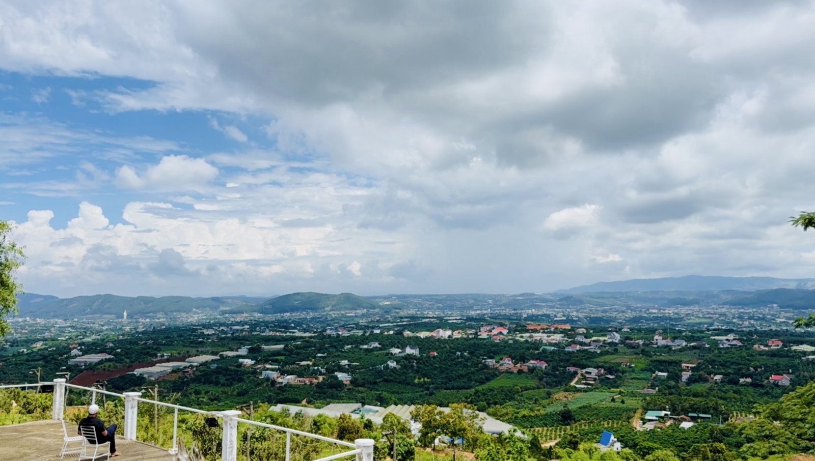 Người ngồi ngắm toàn cảnh thung lũng Nam Ban từ đài ngắm trên đồi