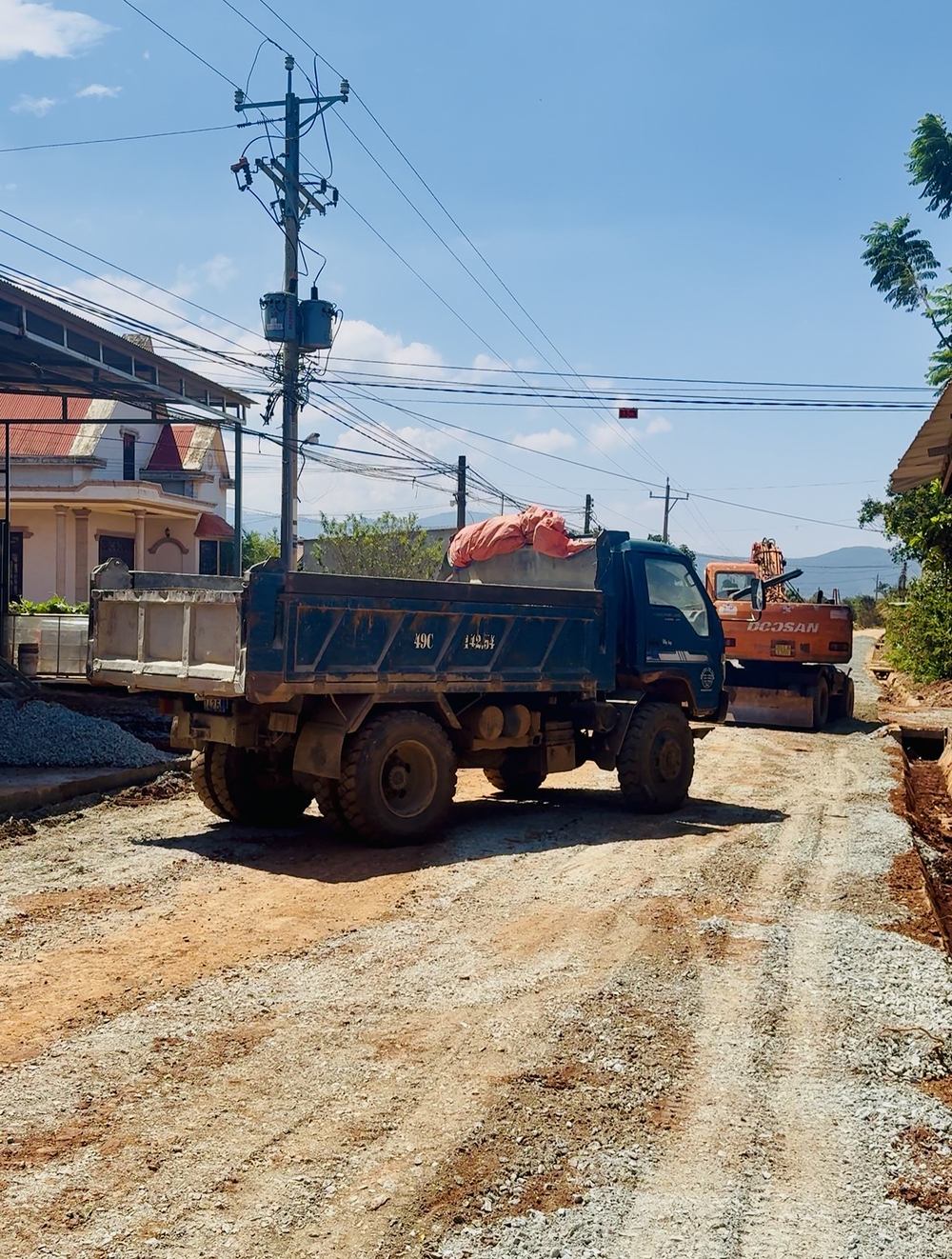 Máy xúc và xe ben trên nền đường đất đỏ tuyến Hà Bắc đang thi công