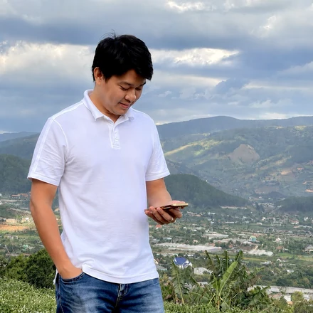 Đoàn Quốc Duyệt in the field at Nam Ban, the valley behind him