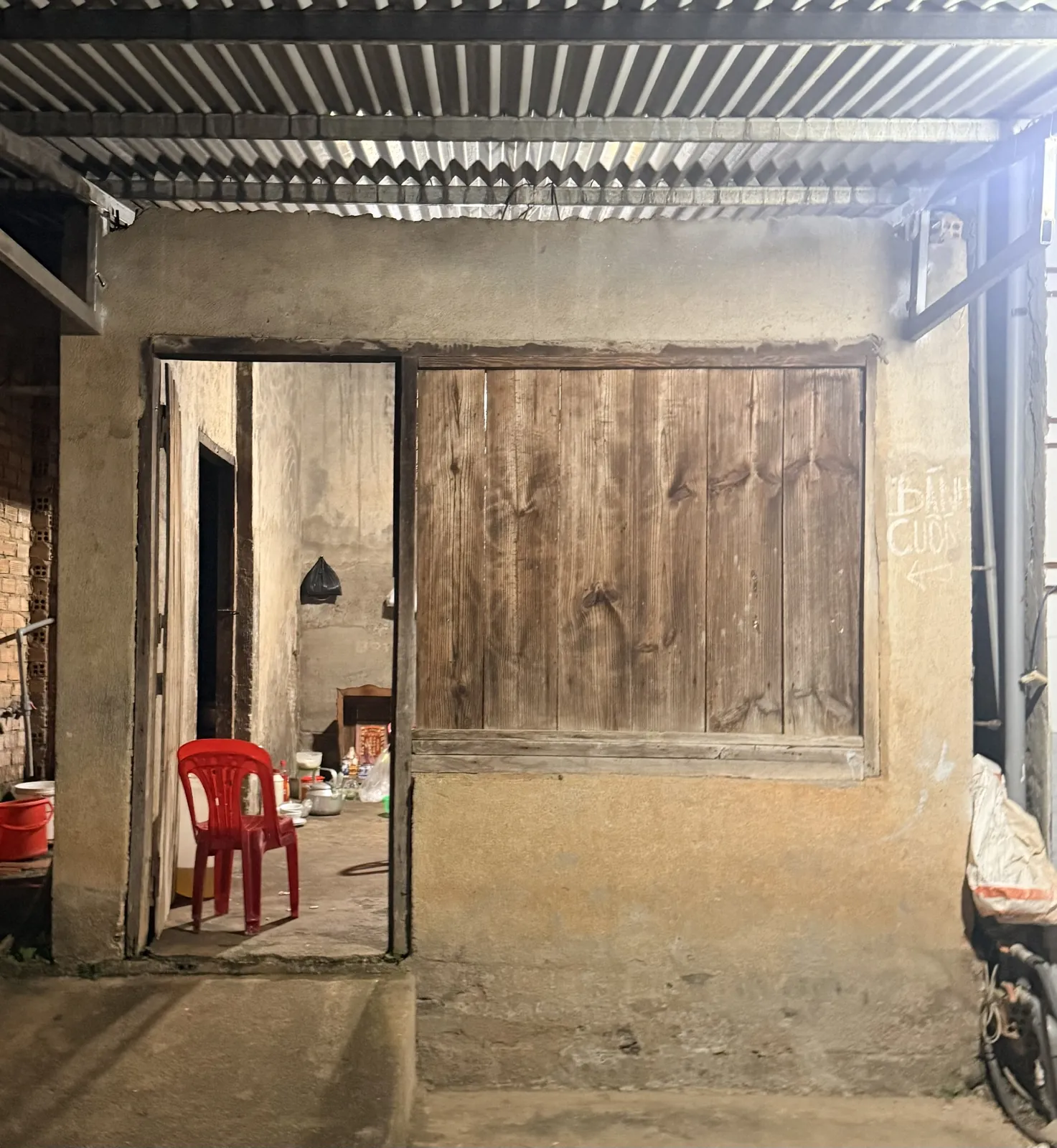 Hàng bánh cuốn trong chợ Gia Lâm, Nam Ban về đêm — nhà cũ, cửa gỗ, chữ bánh cuốn viết trên tường