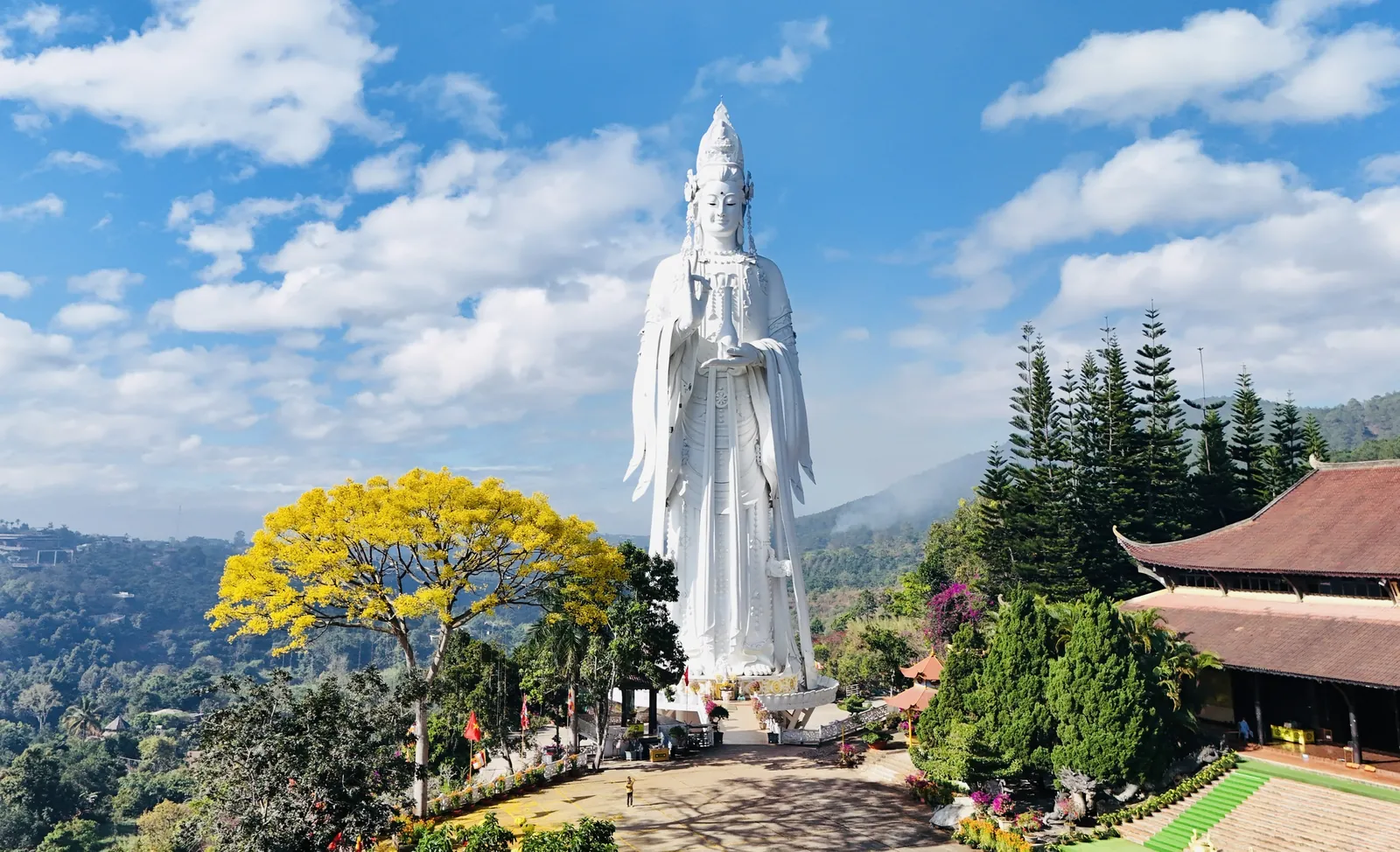 Đại tượng Quán Thế Âm chùa Linh Ẩn Nam Ban cao 71m đứng giữa nền trời, phía sau là đồi xanh