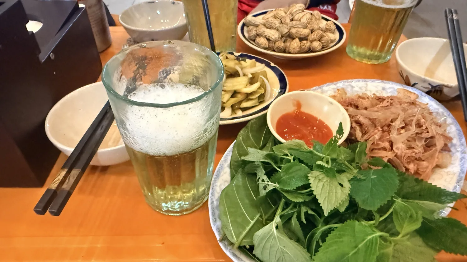 Mâm ăn bình dân với gỏi, rau và đồ nhắm ở Nam Ban