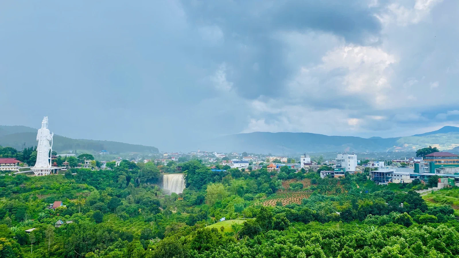 Toàn cảnh Nam Ban nhìn từ trên cao: tượng Quan Âm trắng ở chùa Linh Ẩn bên trái, thác Voi đổ ngay phía dưới, thị trấn và dãy đồi phía sau