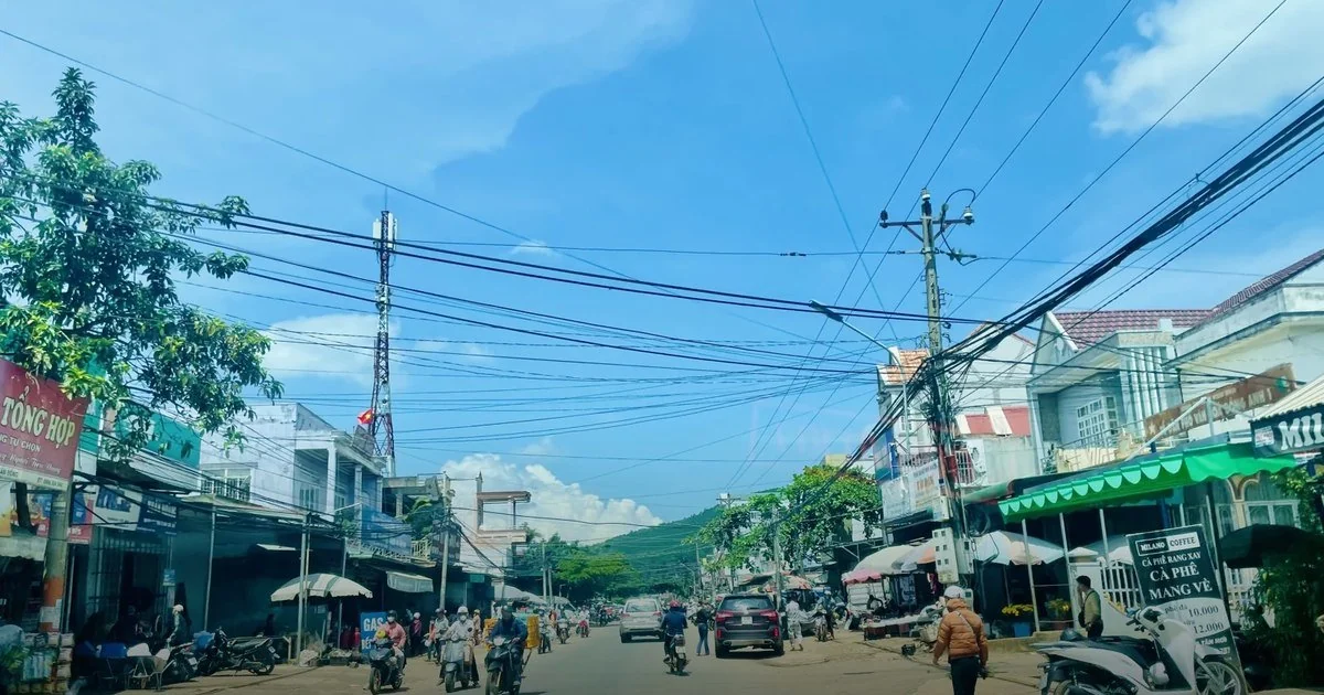 Đường phố trung tâm Nam Ban vào ban ngày, hai bên là hàng quán và chợ, phía xa là đồi
