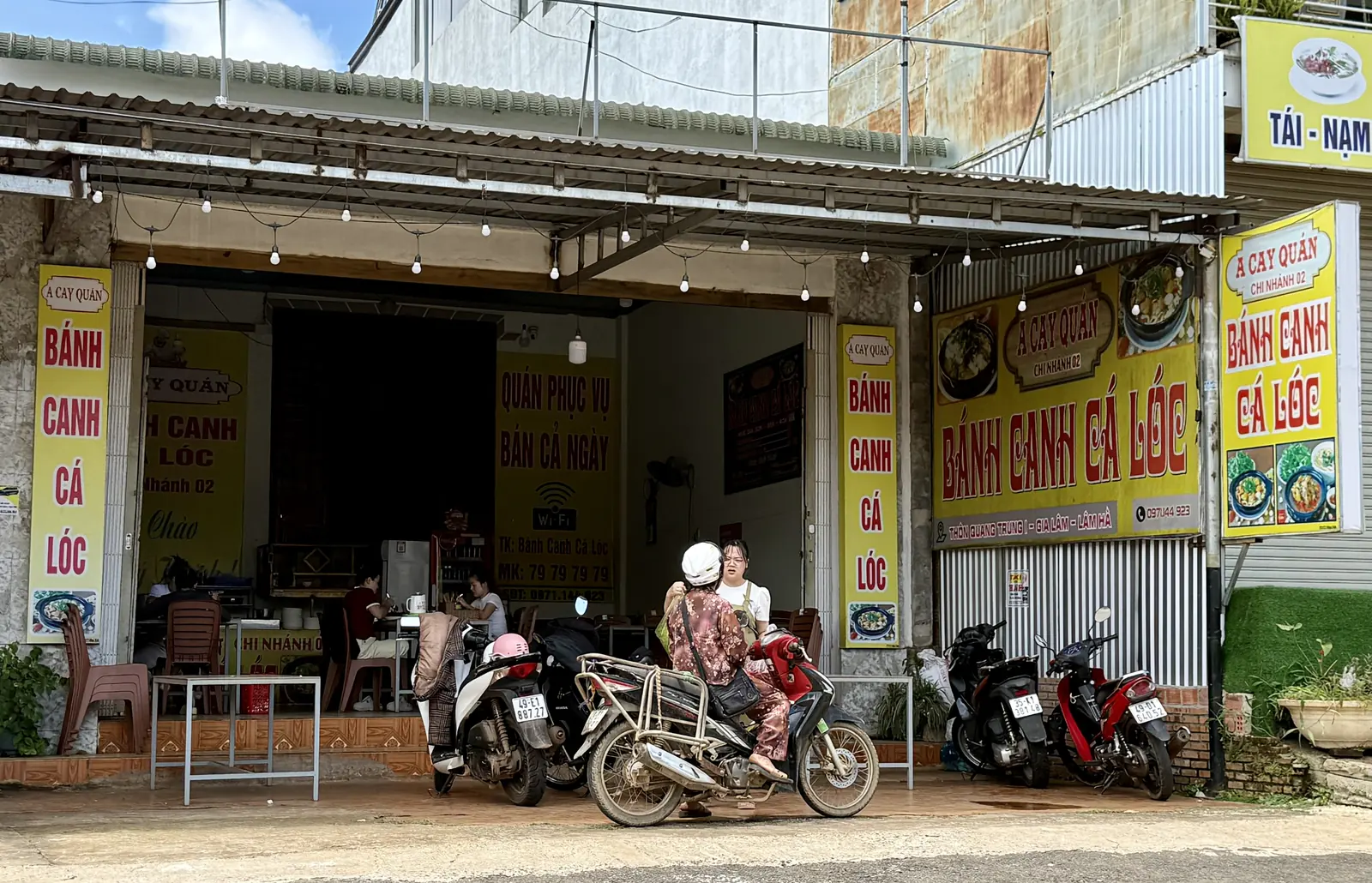 Quán bánh canh cá lóc ven đường ở Nam Ban, người ngồi ăn và xe máy đậu trước quán